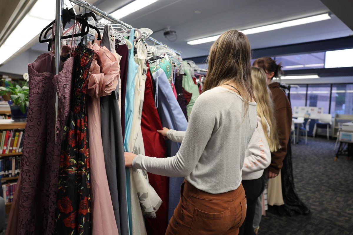 Students browsing through several dresses to find that perfect one